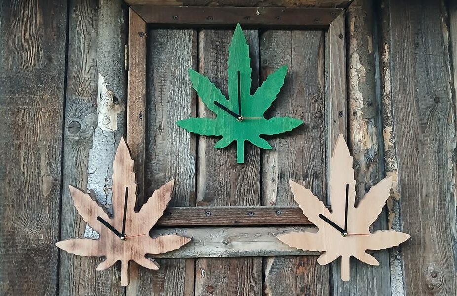 Cannabisblatt-Wanduhr aus Holz mit drei Blättern in Grün und Naturfarben
